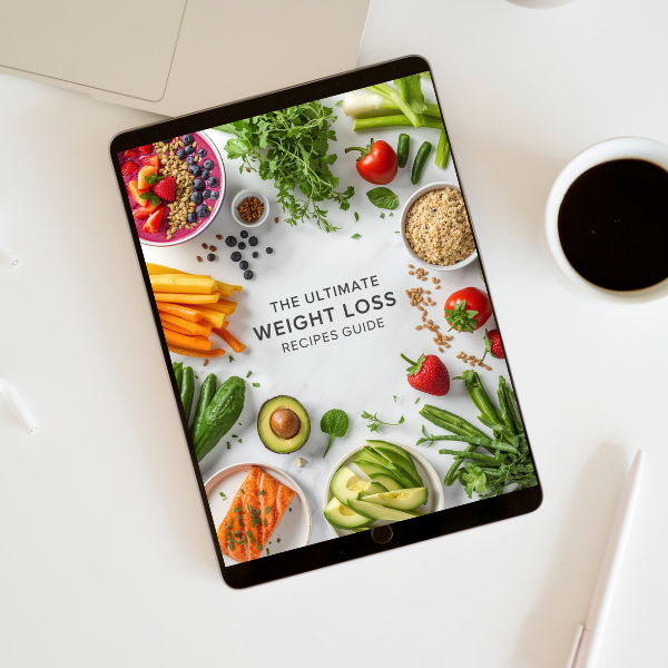 Tablet displaying "Ultimate Weight Loss Recipes Guide" surrounded by healthy foods like avocado, salmon, vegetables, and berries